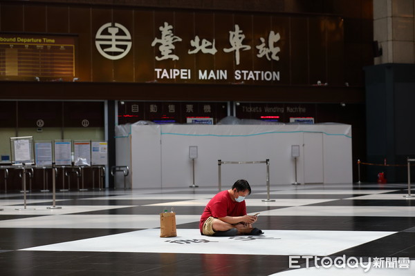 ▲▼疫情街道空景,過去熙來攘往的台鐵大廳，總是聚集大批席地而坐的民眾，疫情升溫後民眾紛紛走避，但仍有一名勇敢的紅衣哥席地而坐。（圖／記者湯興漢攝）