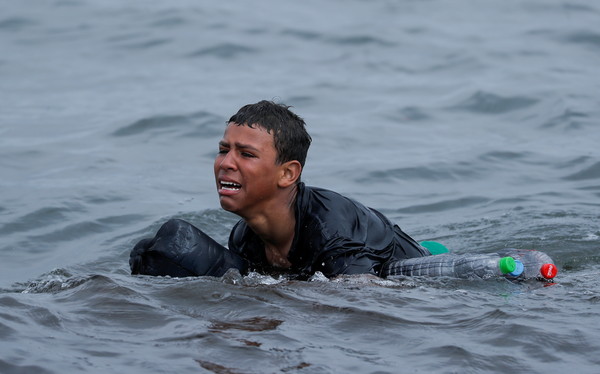 ▲▼ 摩洛哥一名少年游泳前往西班牙海外屬地休達（Ceuta），身上綁著多個空塑膠瓶。（圖／路透）