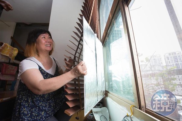 楊賢英在落地窗貼上裏著錫箔紙的軟塑膠瓦愣板，隔絕西曬熱源。
