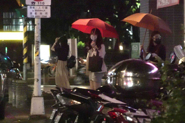  貝貝蕾（左）、潘映竹（中）、蘿莉塔（右）三人結束直播活動後一起離開，貝貝蕾還拿起護目面罩充當雨傘。（圖／攝影組）  