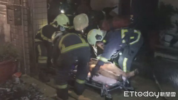 ▲消防隊員發現屋主倒臥在2、3樓樓梯間，但已無生命跡象，救護人員趕緊送醫搶救。（圖／記者黃孟珍攝）