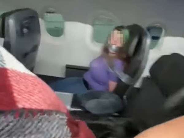 ▲▼美國航空一名女性乘客遭膠帶封嘴綁在座位上。（圖／翻攝自YouTube／Reverse & Release）
