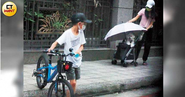 一名女子帶著出現在蕭亞軒舊家的孩子外出騎車兼遛狗，疑似是蕭亞軒的姪子與愛犬。（圖／本刊攝影組）