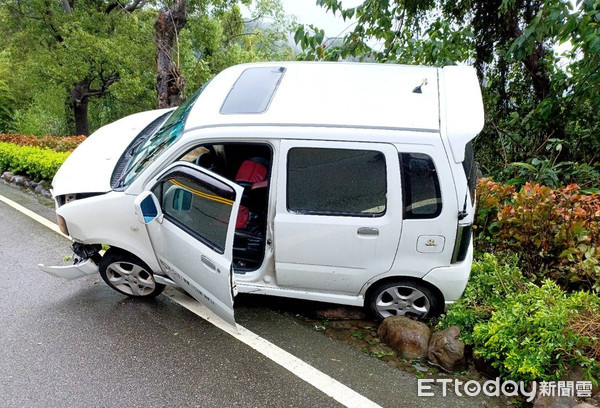 ▲苗栗1名19歲女子，疑似天雨路滑開車自撞路邊石頭，造成左側車頭變形破損。（圖／記者黃孟珍翻攝）