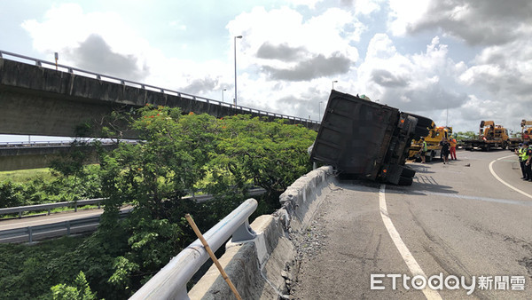 ▲國道1號接國道8號南往東匝道26日下午發生曳引車翻覆交通事故，該車疑未依規定減速而失控翻覆，消防人員搶救謝姓駕駛人脫困送醫。（圖／記者林悅翻攝，下同）