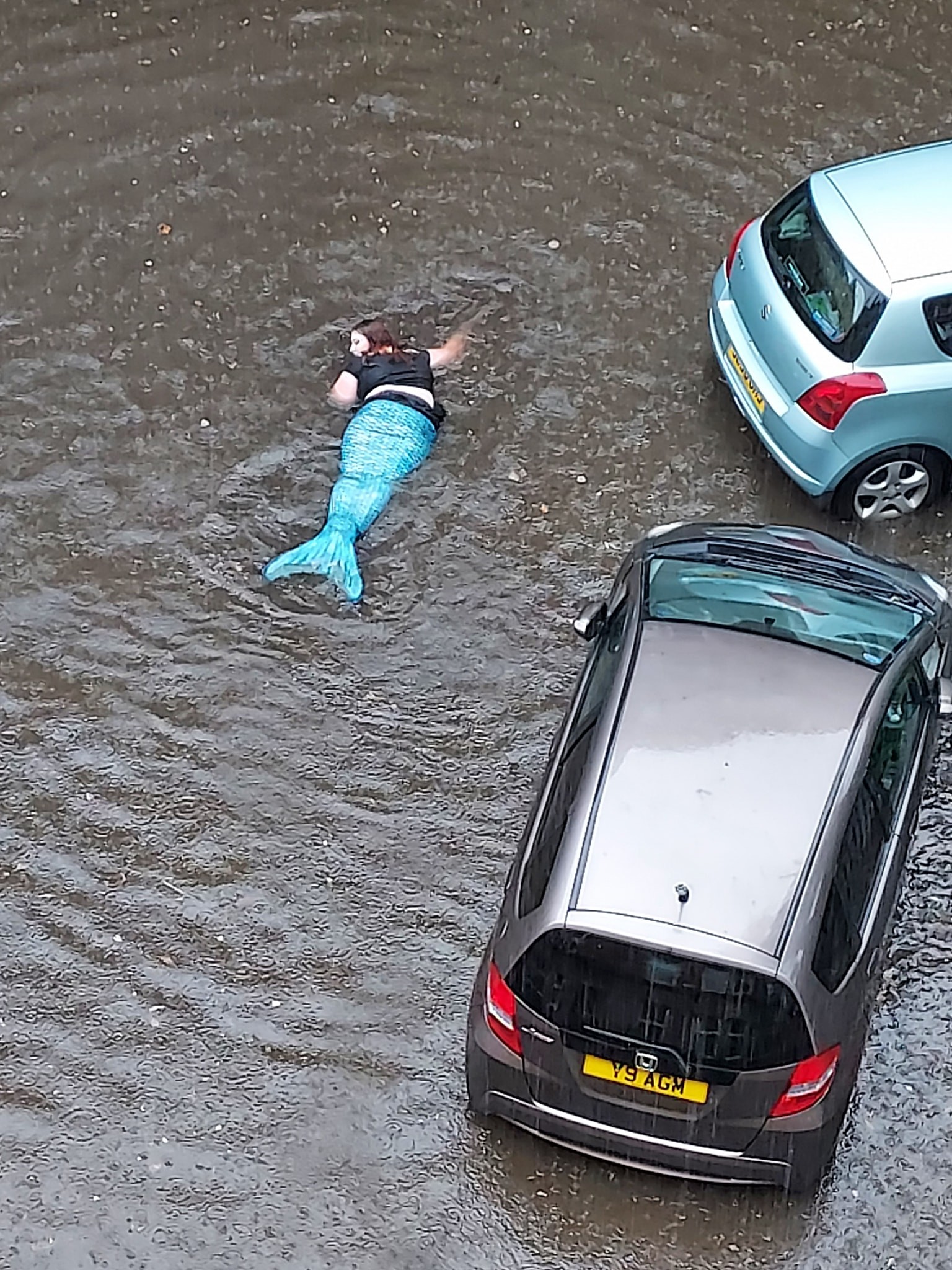 ▲▼英國一名女子扮成美人魚在淹水的路段游泳。（圖／翻攝自Facebook／Gavin Millar）
