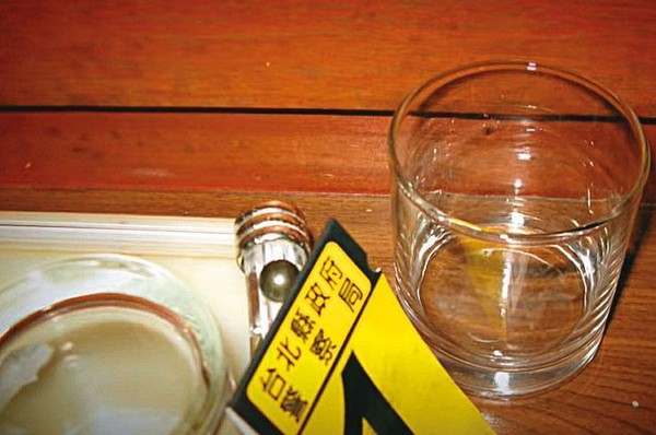 警方在旅館房間內，找到殘留安眠藥粉末的玻璃杯。（翻攝畫面）