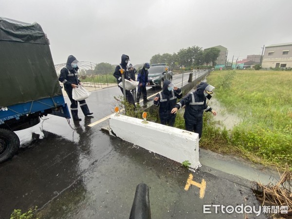 ▲台南市北門區雨勢不斷，部分沿海及低窪地區嚴重積水，海巡第11岸巡隊派員支援搬運沙包協助防災。（圖／記者林悅翻攝，下同）