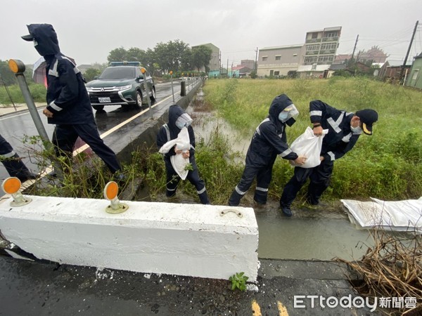 ▲台南市北門區雨勢不斷，部分沿海及低窪地區嚴重積水，海巡第11岸巡隊派員支援搬運沙包協助防災。（圖／記者林悅翻攝，下同）