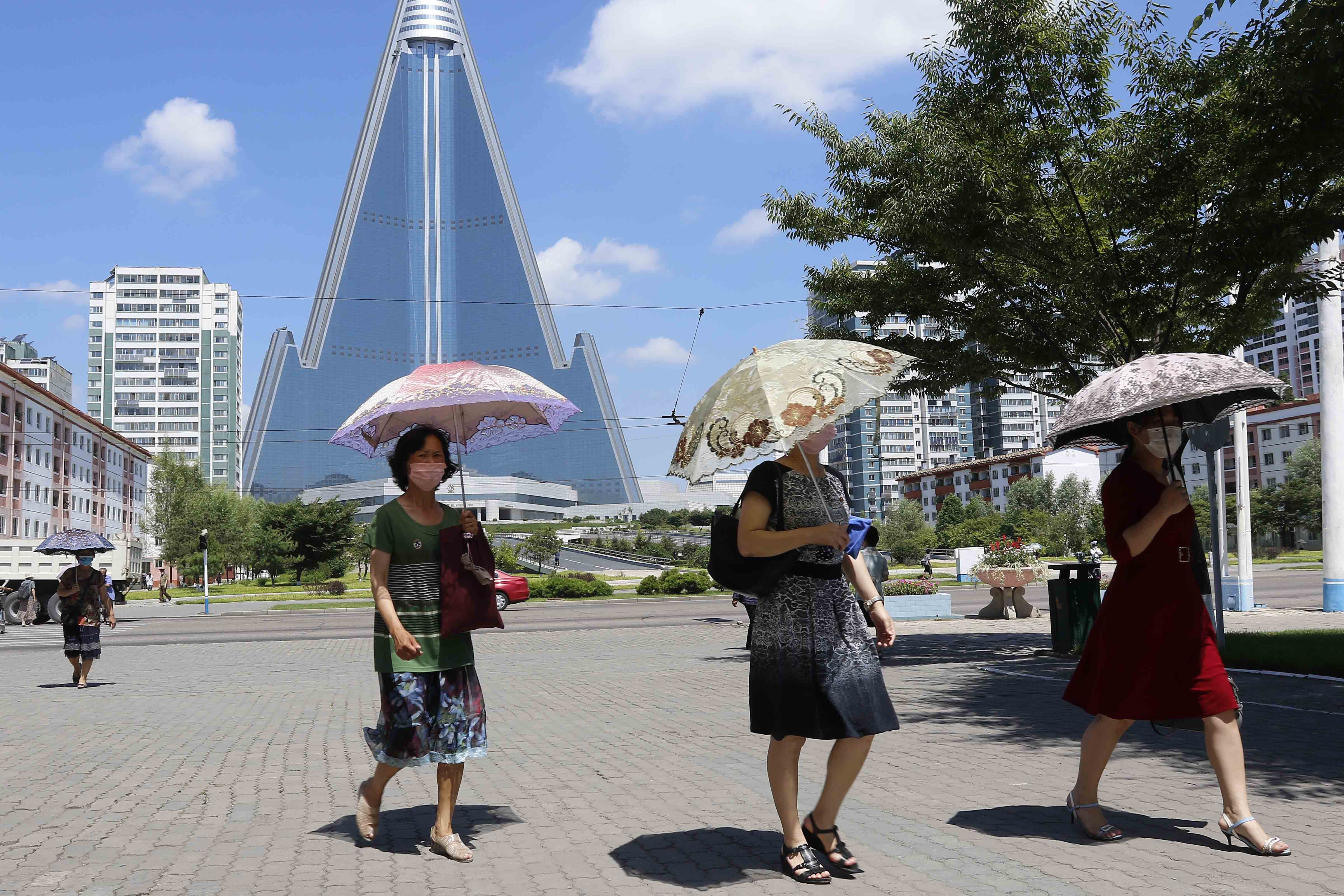 ▲▼北韓首都平壤今年7月的街景，婦女身後建築為105層樓高的柳京飯店。（圖／達志影像／美聯社）