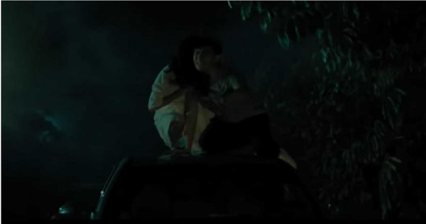 車頂居然坐著一名穿白衣的女子，血盆大口還叼著一顆人頭。（圖／翻攝自電影怨靈2畫面）