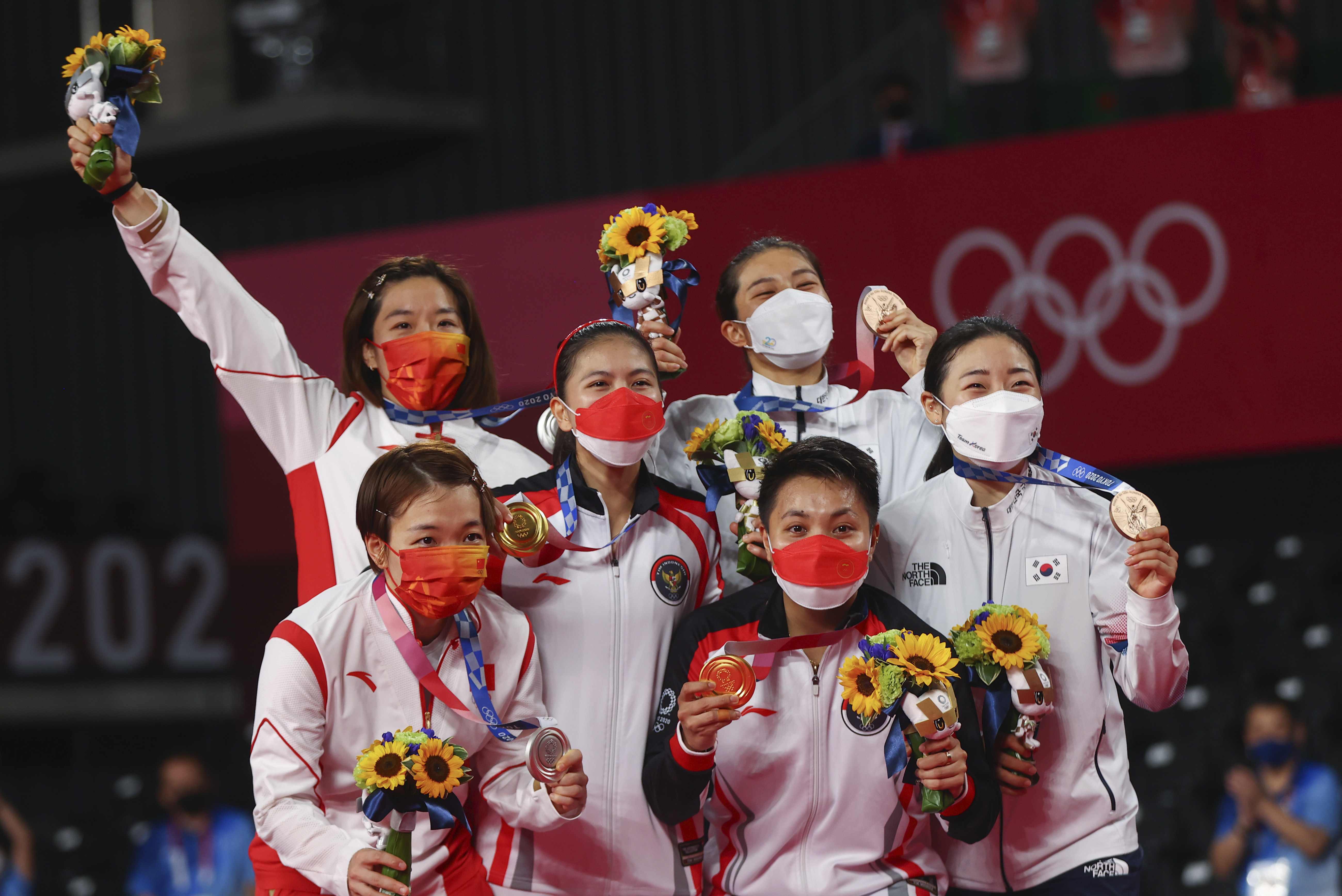 ▲▼中國、印尼、南韓女子羽球雙打選手(由左至右)在頒獎台上興奮地抱成一團。（圖／路透社）
