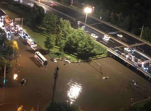 ▲▼北京暴雨一鐵路橋下兩人駕車涉水被困。（圖／翻攝自微博）