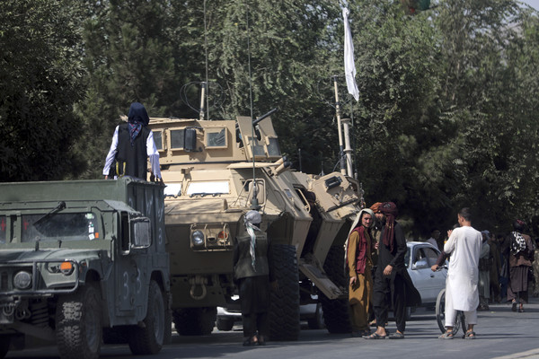 ▲▼塔利班武裝分子在通往喀布爾國際機場的路上站崗，一旁還有軍用裝甲車。（圖／達志影像／美聯社）