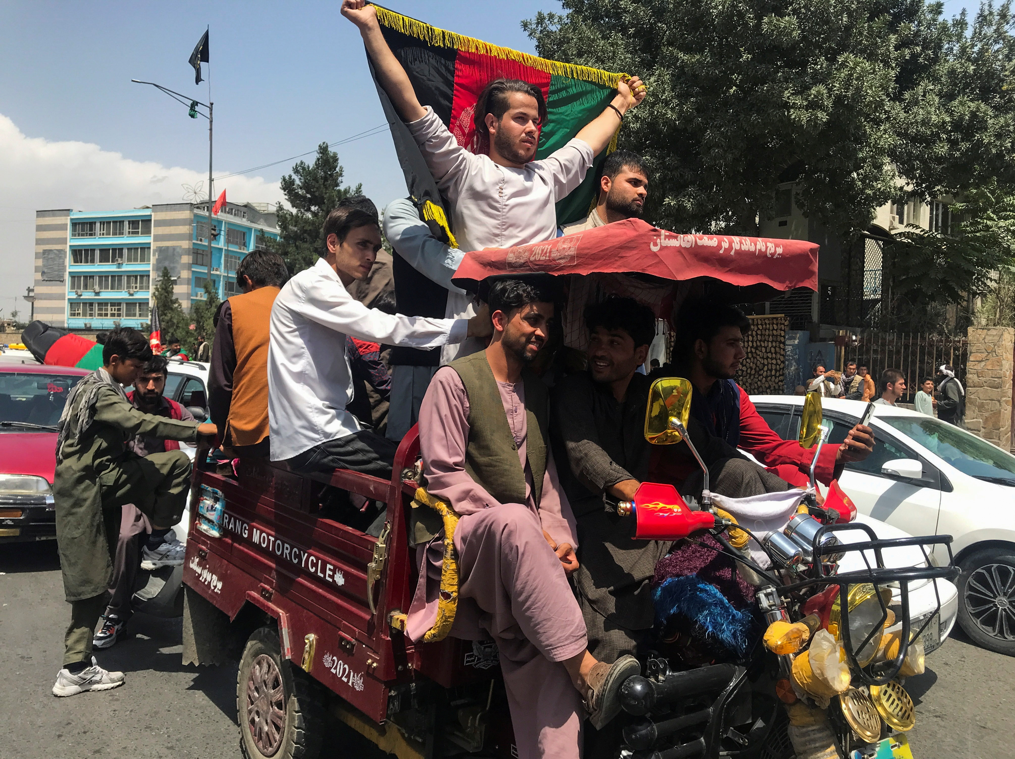 ▲▼民眾在喀布爾街頭高舉旗幟紀念阿富汗獨立日，喀布爾即日起實施宵禁。（圖／路透社）