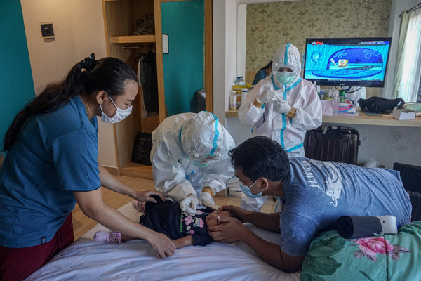 ▲▼ 印尼衛生工作者幫嬰兒採集檢體，檢測是否感染新冠病毒。（圖／達志影像）