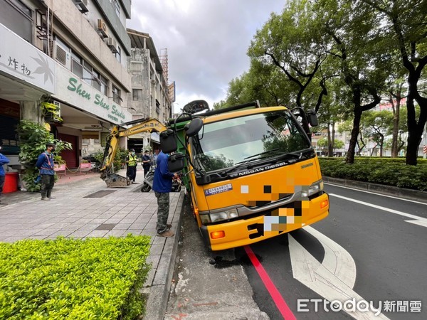 ▲▼工程車後輪卡進水溝，整輛車傾斜30度。（圖／記者許宥孺翻攝）