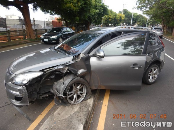 ▲▼男子開車過彎自撞，路燈遭撞倒，車也卡在分隔島上。（圖／民眾提供）