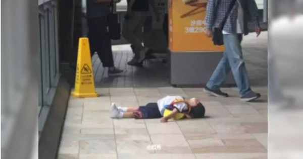 男童不想上學，躺在地上耍賴讓媽媽相當苦惱。（圖／翻攝自中國報）