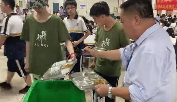 ▲湖南一高中校長一天三餐站在垃圾桶旁吃學生剩菜。（圖／翻攝瀟湘晨報）