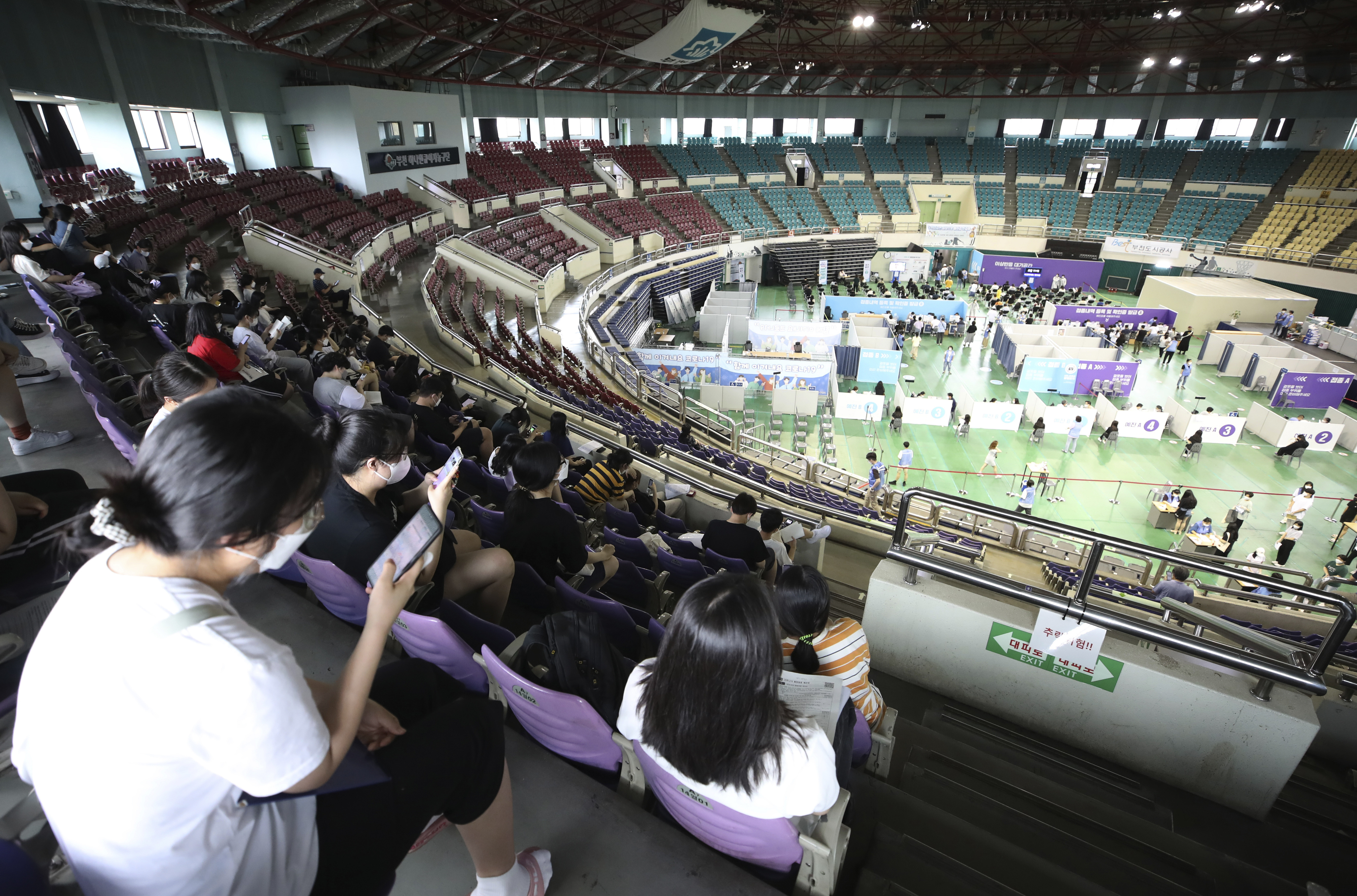 ▲▼南韓京畿道富川市某體育場館內，高中生與教職人員等候施打第1劑輝瑞疫苗。（圖／達志影像／美聯社）