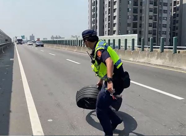 ▲▼一輛聯結車在西濱快速路爆胎，清水警驚險忍痛拖離又重又燙的輪胎皮。（圖／警方提供）