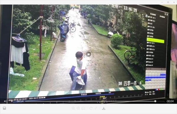 ▲上海一名年輕女子在租屋處遇害，社區監視器拍下犯嫌拖行李箱從居民樓門口走出。（圖／翻攝上游新聞）