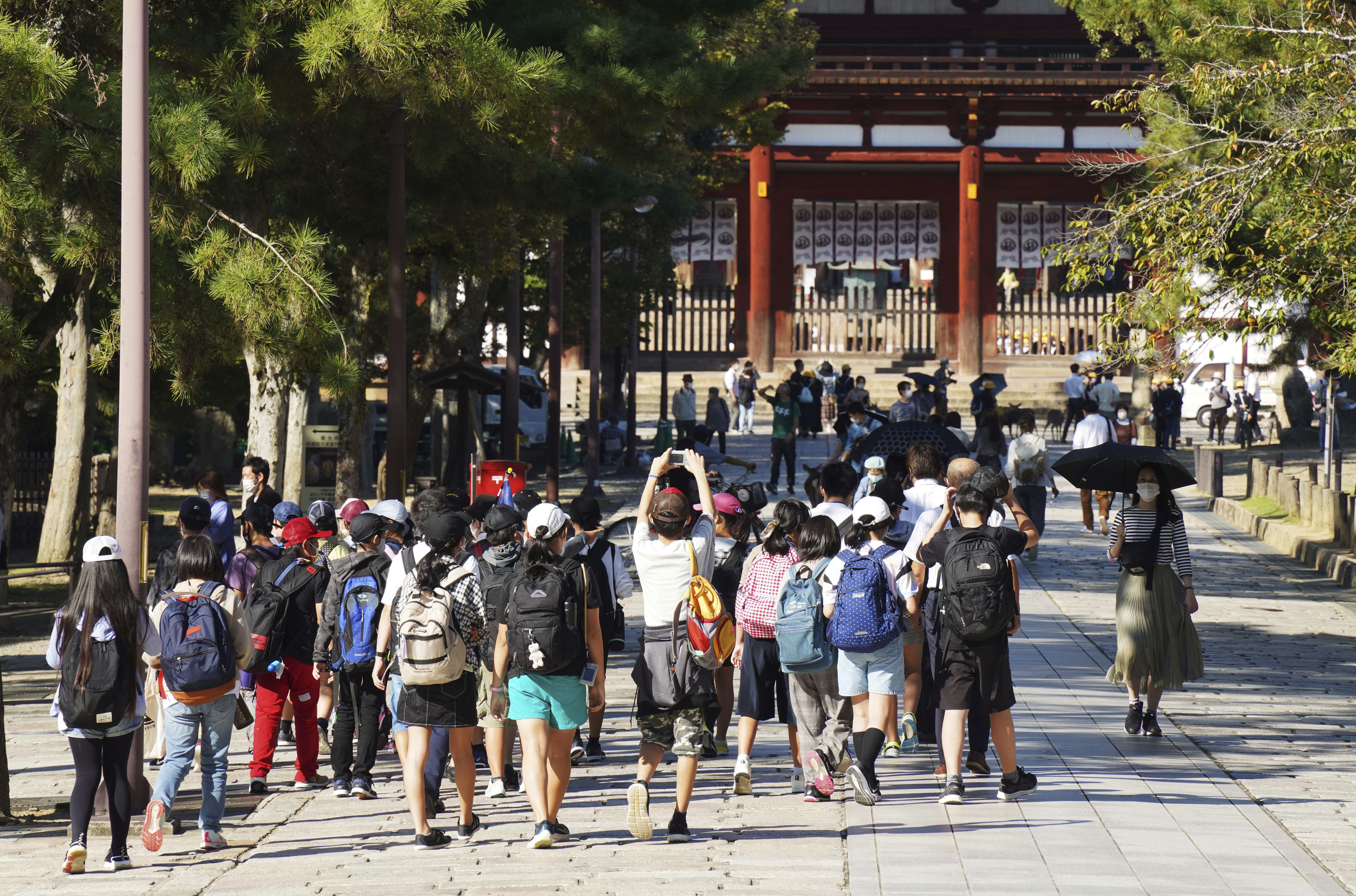 ▲▼日本國內新冠疫情趨緩，圖為15日奈良東大寺附近戴著口罩的遊客與學生。（圖／達志影像／美聯社）