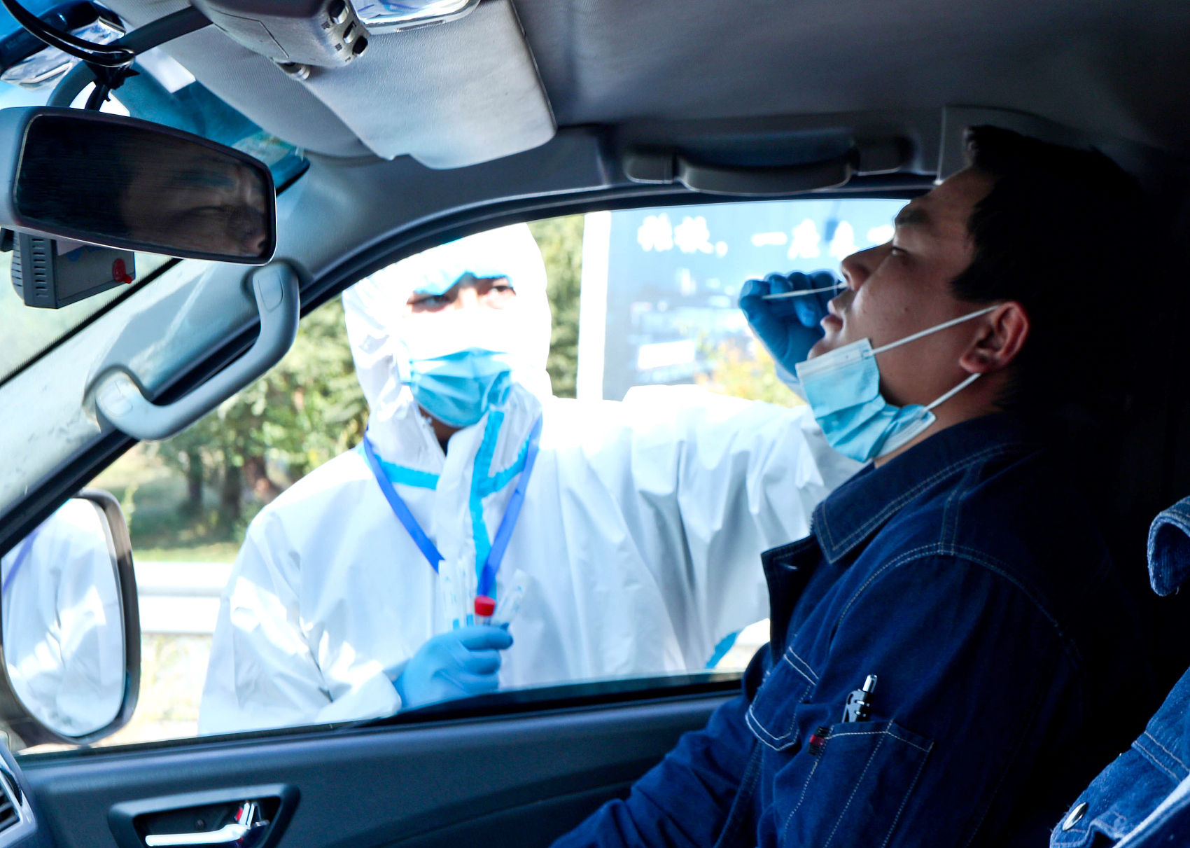 ▲甘肅張掖防疫人員替外來車輛駕駛進行核酸檢測。（圖／CFP）
