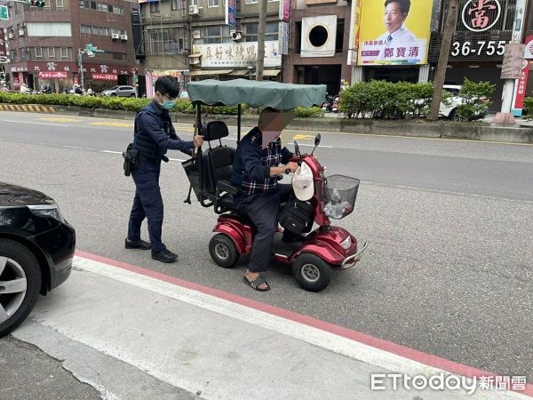 ▲老翁電動車因沒電「刁車」員自後方賣力推車。（圖／桃園警分局提供）