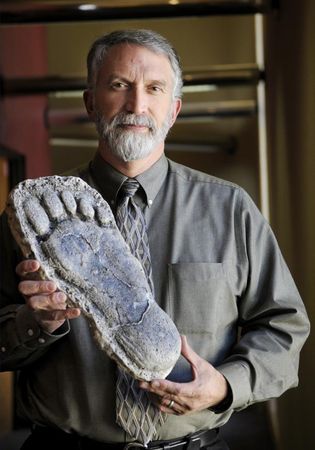 美國愛荷華州立大學的生物教授，拿著一件大腳怪腳印的化石複製品。（翻攝Sasquatch Chronicles Facebook）