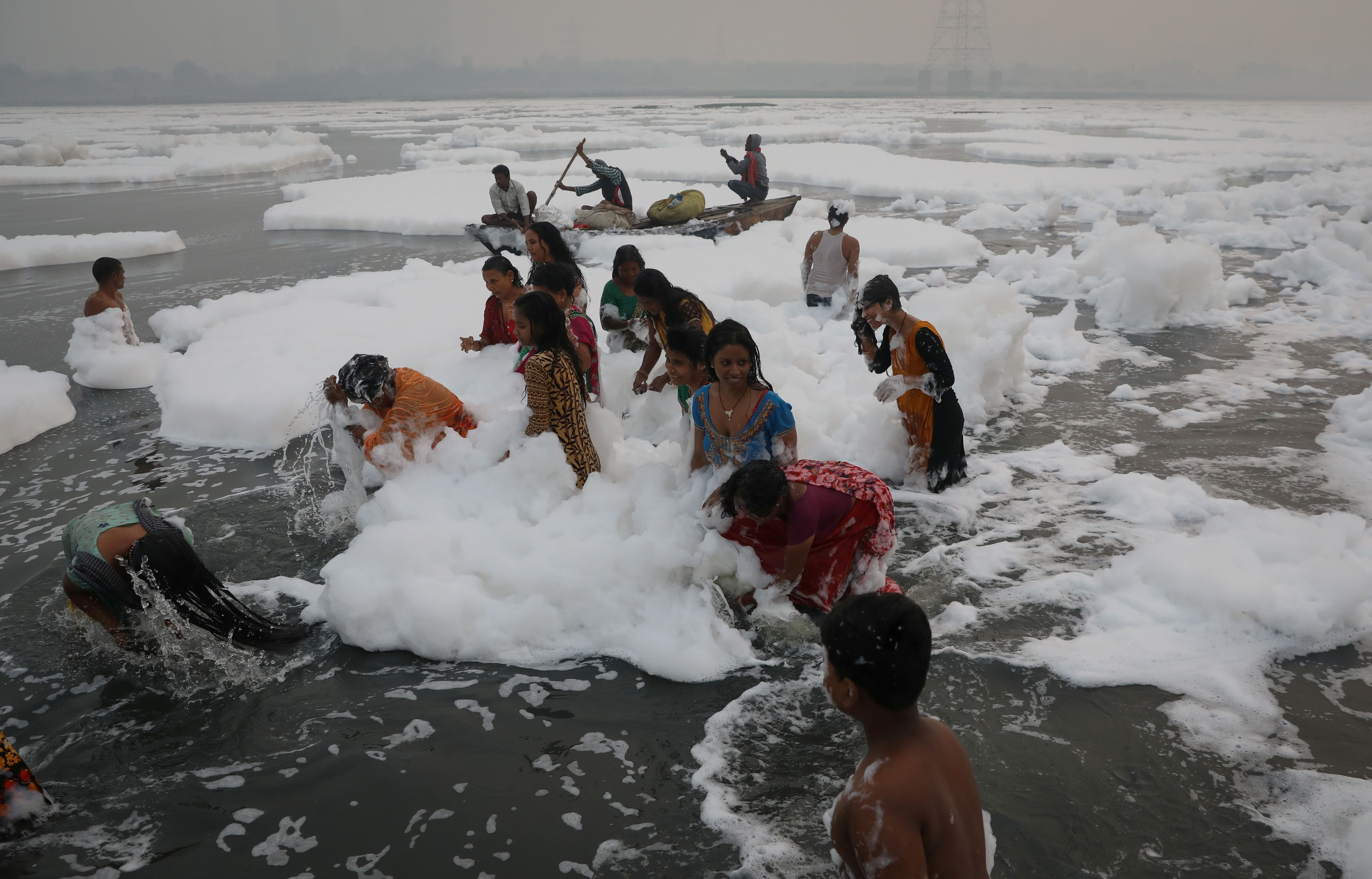▲▼印度首都新德里的「聖河」亞穆納河（Yamuna river）飄滿白色有毒泡沫，民眾仍在祭典時在河裡浸泡、沐浴，甚至玩起了泡泡。（圖／路透）