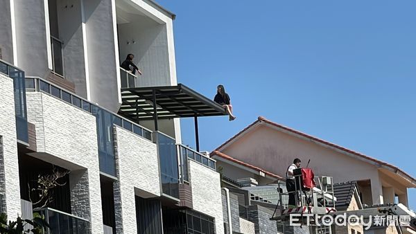 ▲高雄楠梓區一名女子攀爬到4樓的遮雨棚，情緒相當激動            。（圖／記者吳世龍攝）