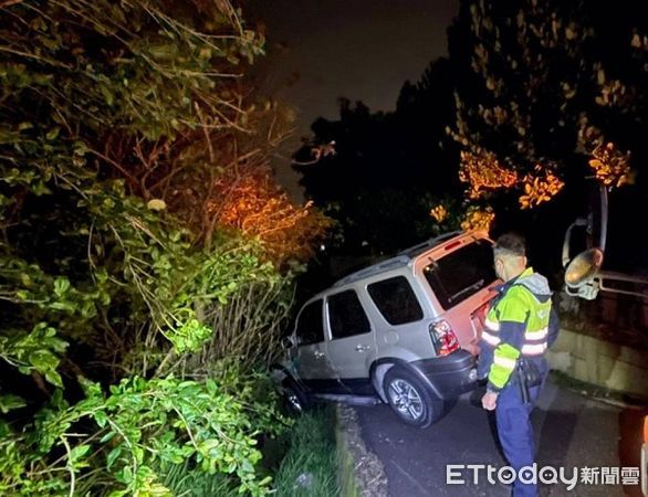 ▲柯男駕車在窄巷會車不慎掉入水溝裡搖搖欲墜。（圖／大園警分局提供）