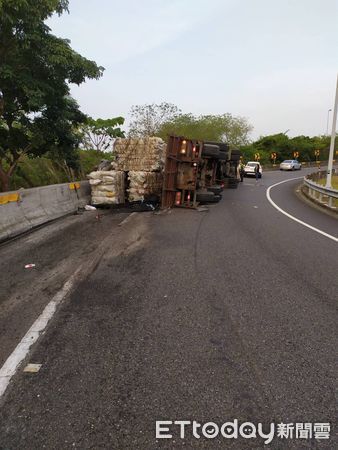 ▲國道3號南向320公里東山服務區入口匝道，發生營業半聯結車翻車交通事故，造成車上1名女乘客腳部夾傷送醫診治，車上散落貨物於地。（圖／記者林悅翻攝，下同）