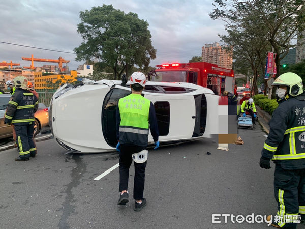 ▲19日下午汐止區新台五路2段一輛自小客車疑似未注意車前狀況擦撞路邊小客車翻覆，這起車禍造成兩人送醫。（圖／記者張君豪翻攝）