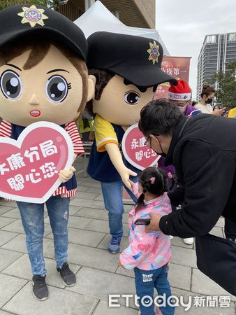 ▲永康警分局犯罪預防宣導團，出動大頭警察娃娃，並手持宣導標語，熱情與民眾揮手互動，萌萌的大頭警察娃娃相當吸晴。（圖／記者林悅翻攝，下同）