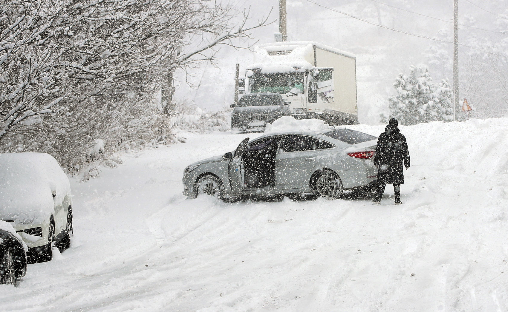 ▲▼南韓全羅南道木浦市降下暴風雪，導致民眾駕駛的車輛無法成功爬上坡。（圖／CFP）