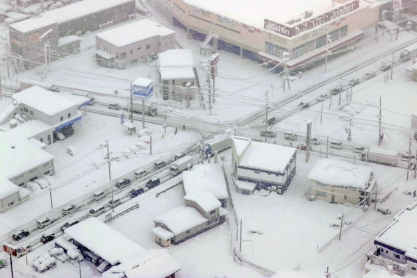 ▲▼強烈寒流襲日，東京睽違45年12月冷到零下，滋賀縣彥根市則有車陣回堵在大雪中。（圖／路透）
