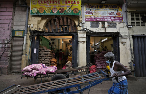 ▲▼斯里蘭卡通貨膨脹嚴重，首都可倫坡一名勞工推著手推車經過批發市場中的一家蔬菜商店。（圖／達志影像／美聯社）