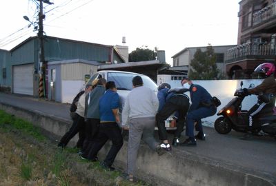 23歲女業務會車出包「右前輪懸空」　警民8人用抬的搞定