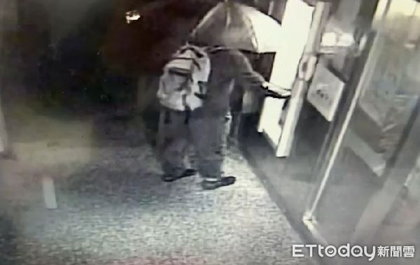 ▲陳嫌用雨傘遮臉，企圖躲避追緝。（圖／記者郭世賢翻攝）