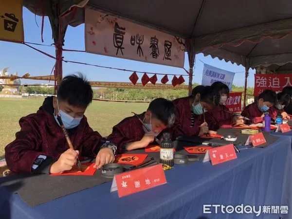 ▲揮毫書法家中一對謝姓小兄弟分別名為「謝天」「謝地」，福氣的名字更是吸引民眾搶著換取其筆墨希望為新年帶來好運，現場活動氣氛熱絡。（圖／記者蔡佩旻翻攝）