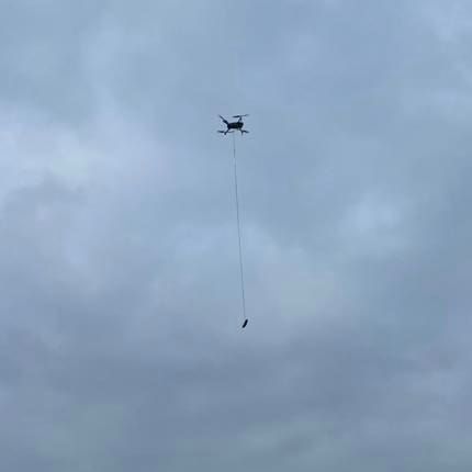 ▲救援隊利用無人機吊著香腸誘導小狗走出泥沼，順利獲救。（圖／Denmead Drone Search & Rescue）