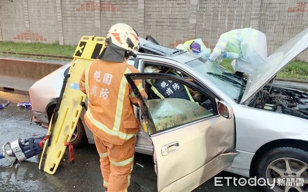 ▲國一南下中壢南下路段19日清晨發生大貨車追撞事故，被撞轎車嚴重毀損，消防人員搶救受困駕駛。（圖／記者沈繼昌翻攝）