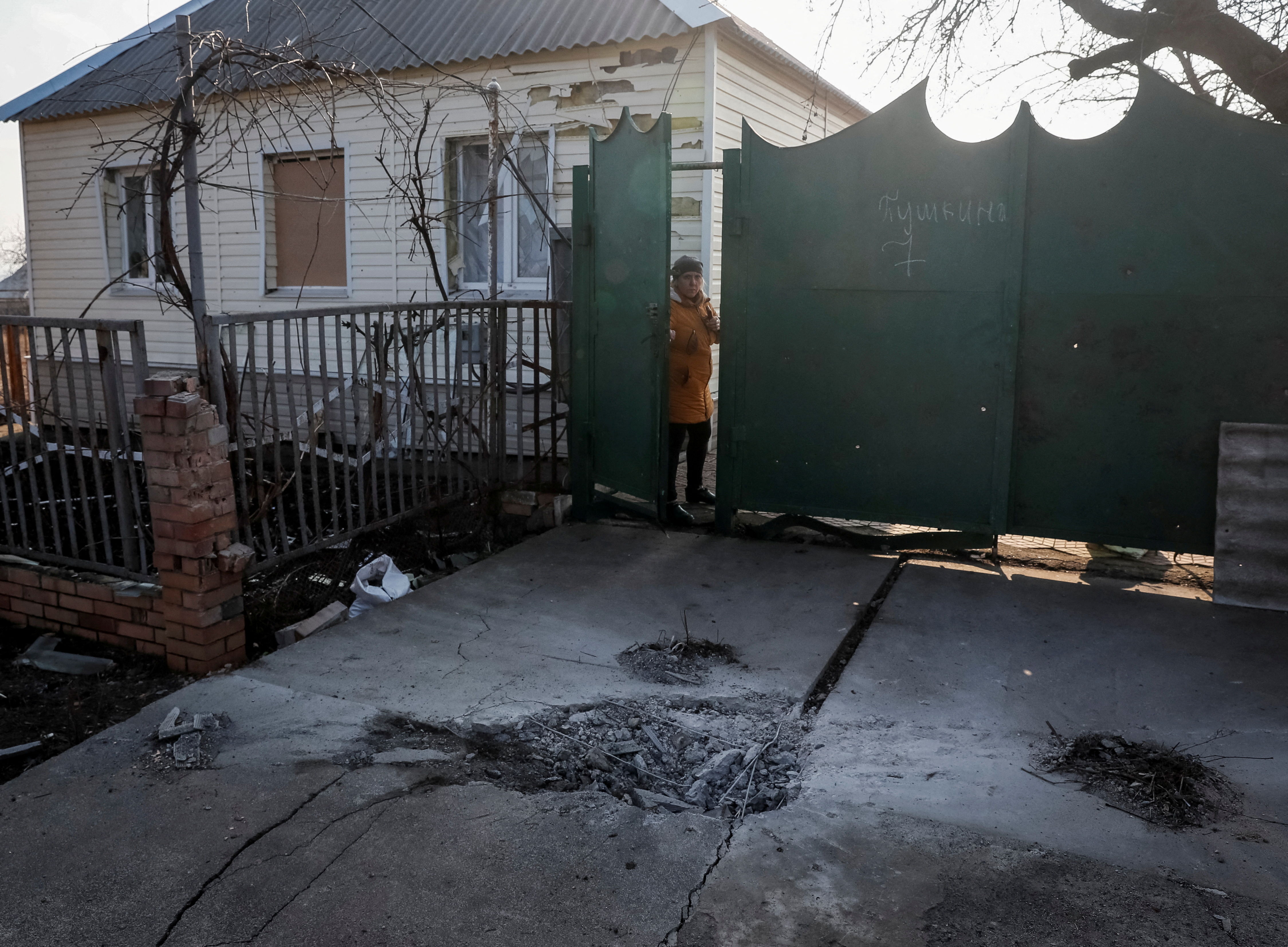 ▲▼烏克蘭東部頓內茨克（Donetsk）地區一處民宅門口遭到砲轟，地上炸出砲彈坑洞。（圖／路透）