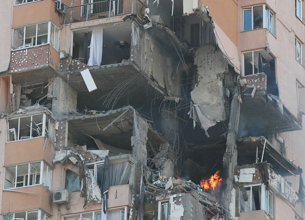 ▲▼烏克蘭基輔26日上午一棟住宅大樓遭俄軍導彈轟炸，建物外牆遭炸出一個大洞，消防人員緊急滅火與搜救，現場還出現沾有血跡的襯衫。（圖／路透）