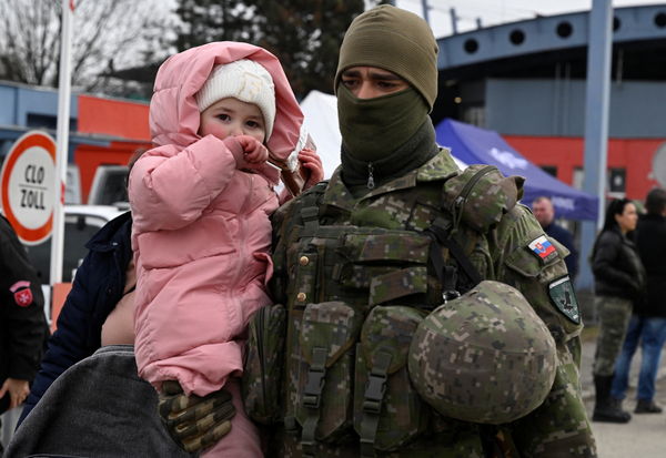 ▲▼一名斯洛伐克武裝部隊成員帶著逃離烏克蘭的孩子與家人一起抵達斯洛伐克。（圖／路透）
