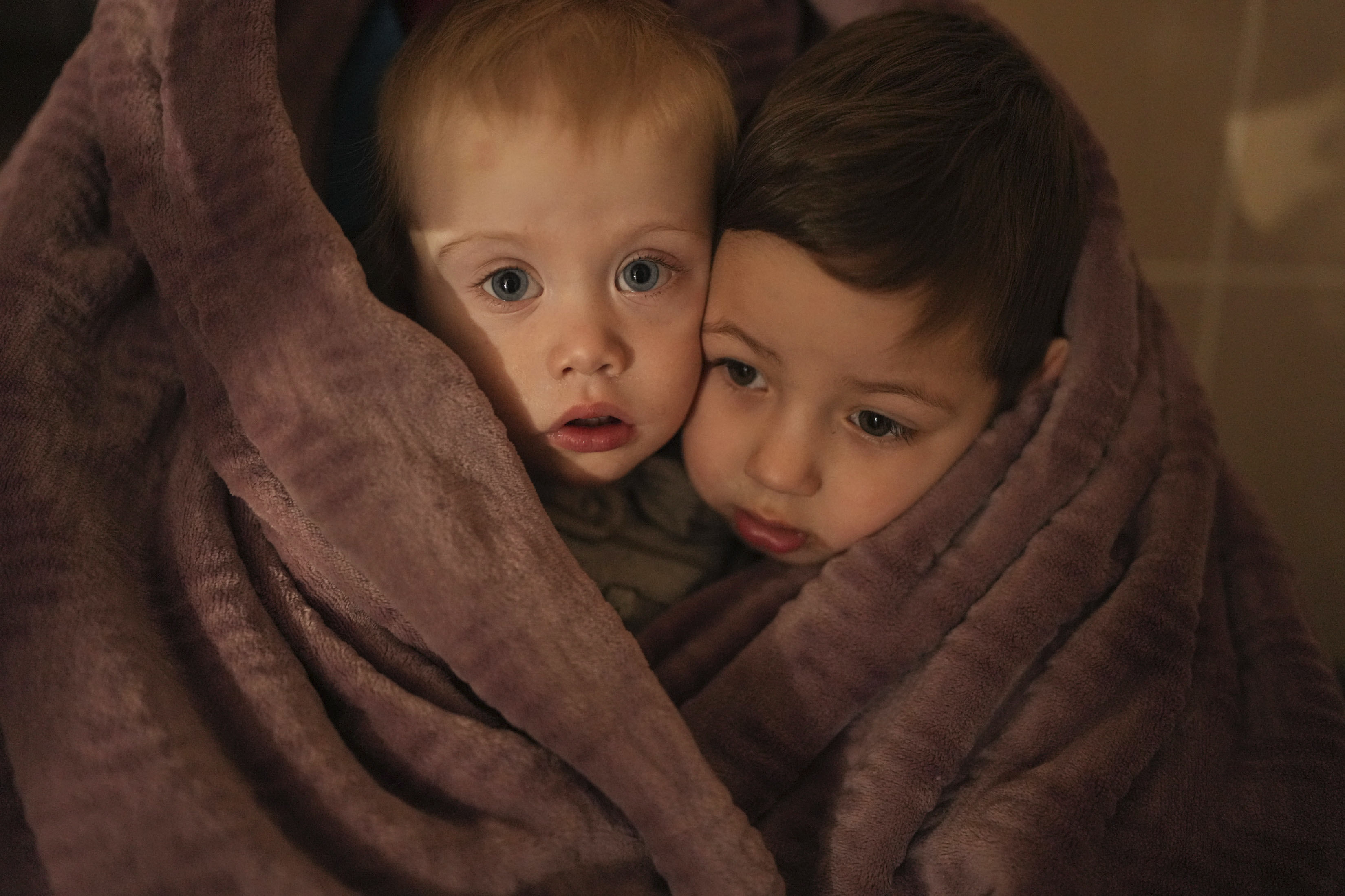 ▲▼ 烏克蘭南部港口城市馬力波（Mariupol）一家醫院裡，醫護人員的子女裹著毯子取暖。（圖／達志影像／美聯社）