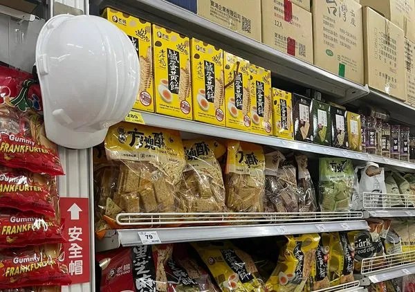 ▲▼大賣場的餅乾區掛著白色工地安全帽。（圖／翻攝自Facebook／爆廢公社二館）